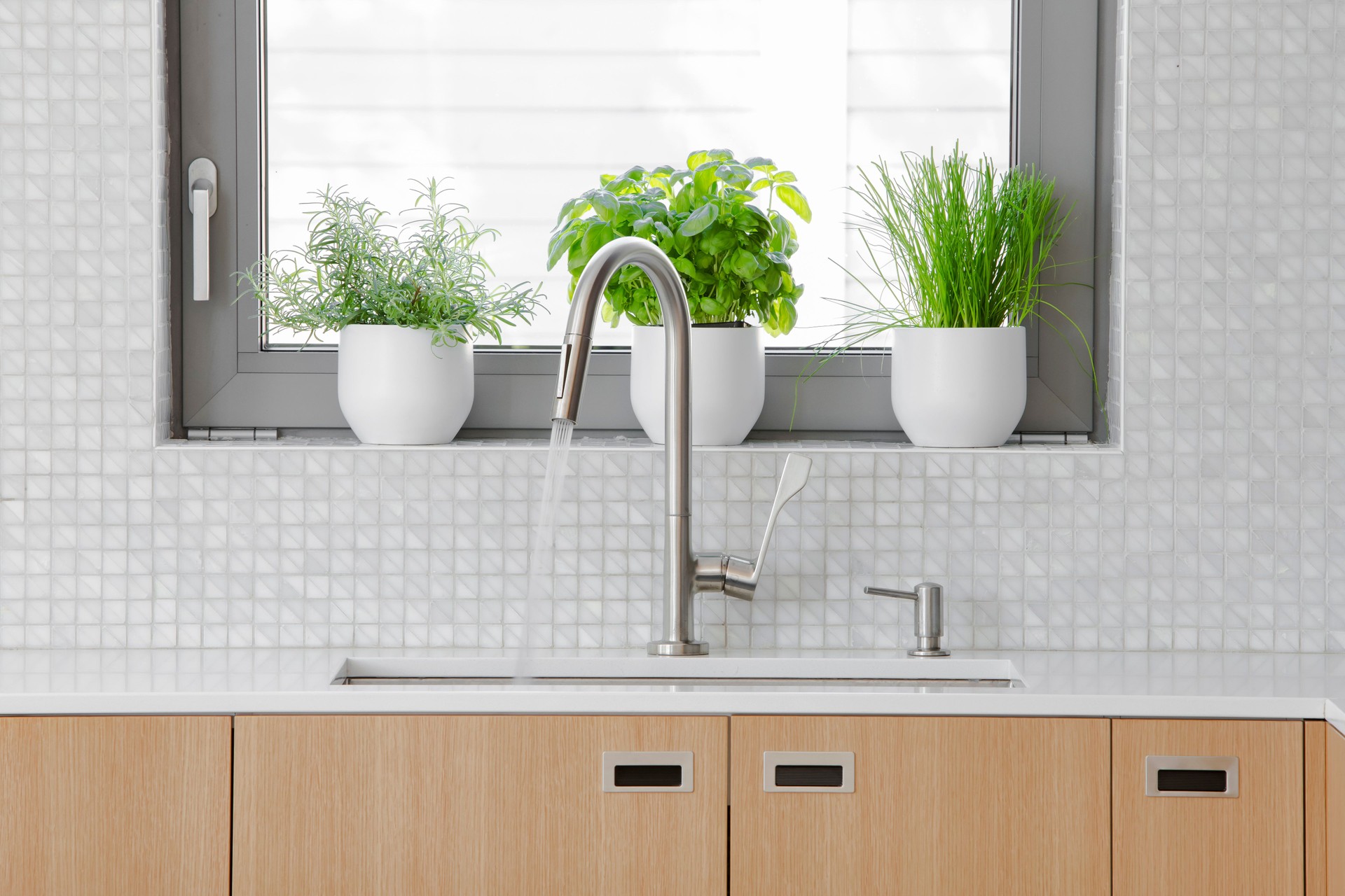 Modern kitchen Stainless steal faucet with water running into sink.